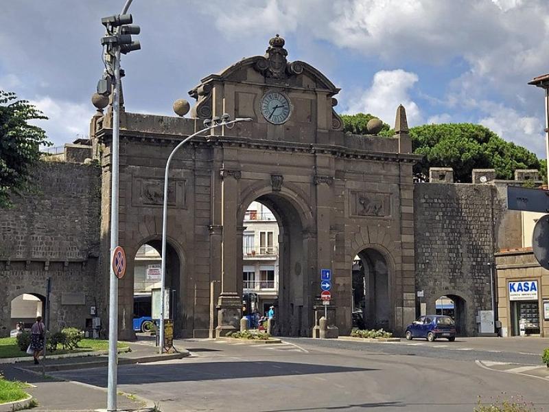 Ingresso città di Viterbo tramite porte scavate nelle mura della città. L'arco è sormontato da un grande orologio e preceduto da una strada